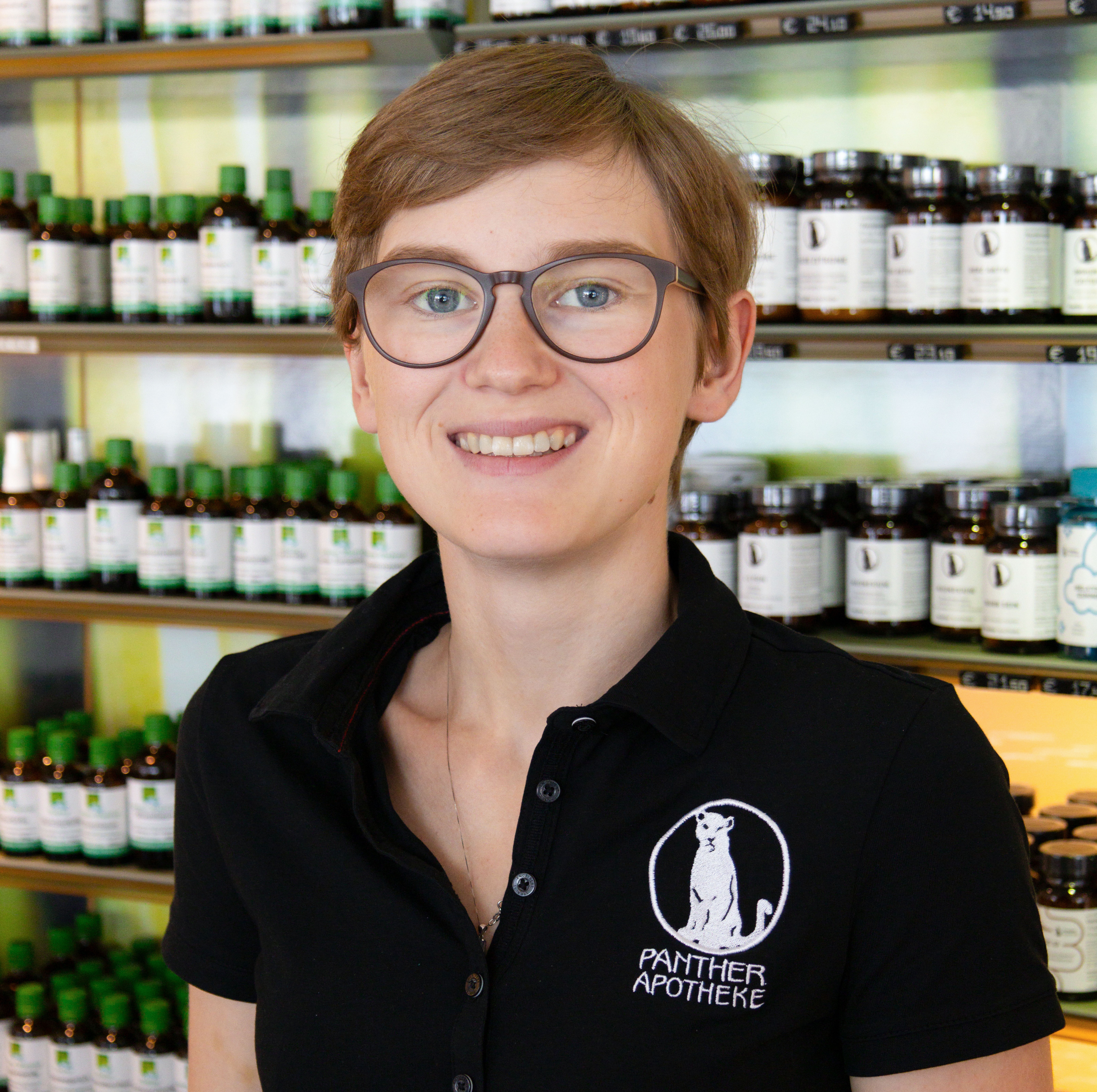 Porträt von Celine Unterweger, stehend vor einem Produktregal.